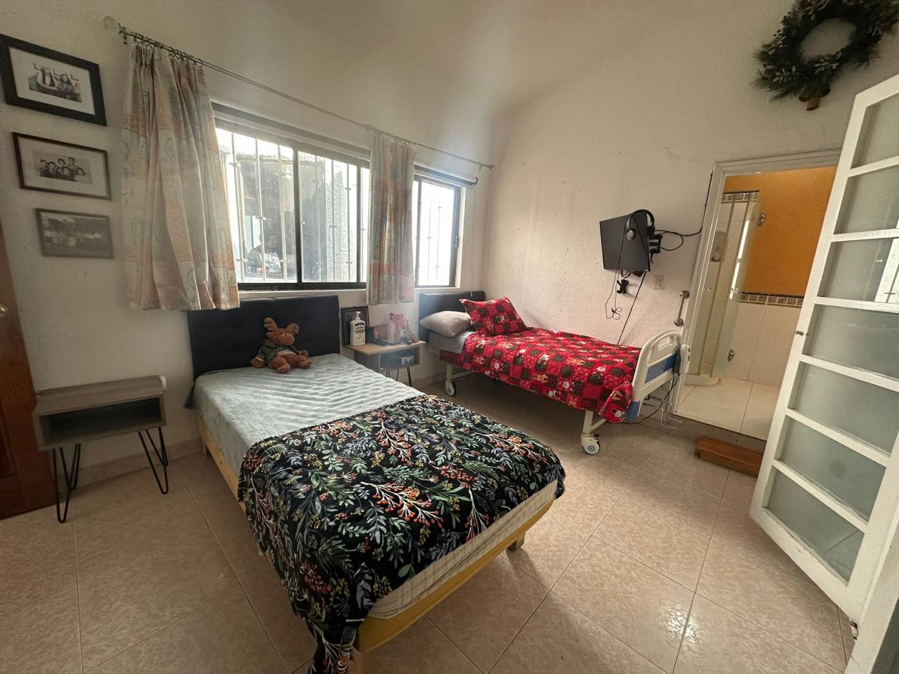 Habitación compartida luminosa con camas de hospital y ambiente cálido